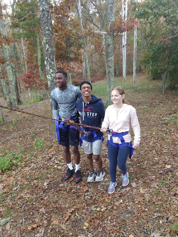 Three students demonstrating blog belay in adventure education